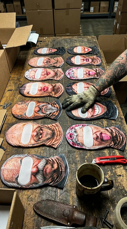 13 UGGLY masks laid out on the warehouse workbench